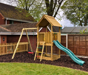 Aire de jeux en bois pour jardin avec toboggan et balançoire dans une cour arrière